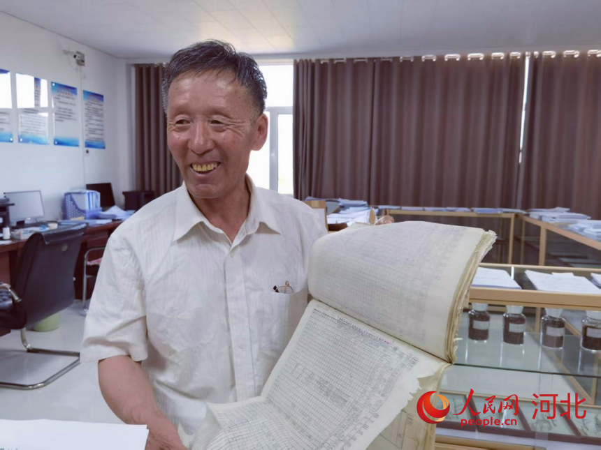 袁德水展示他記錄的育種檔案。人民網 朱延生攝